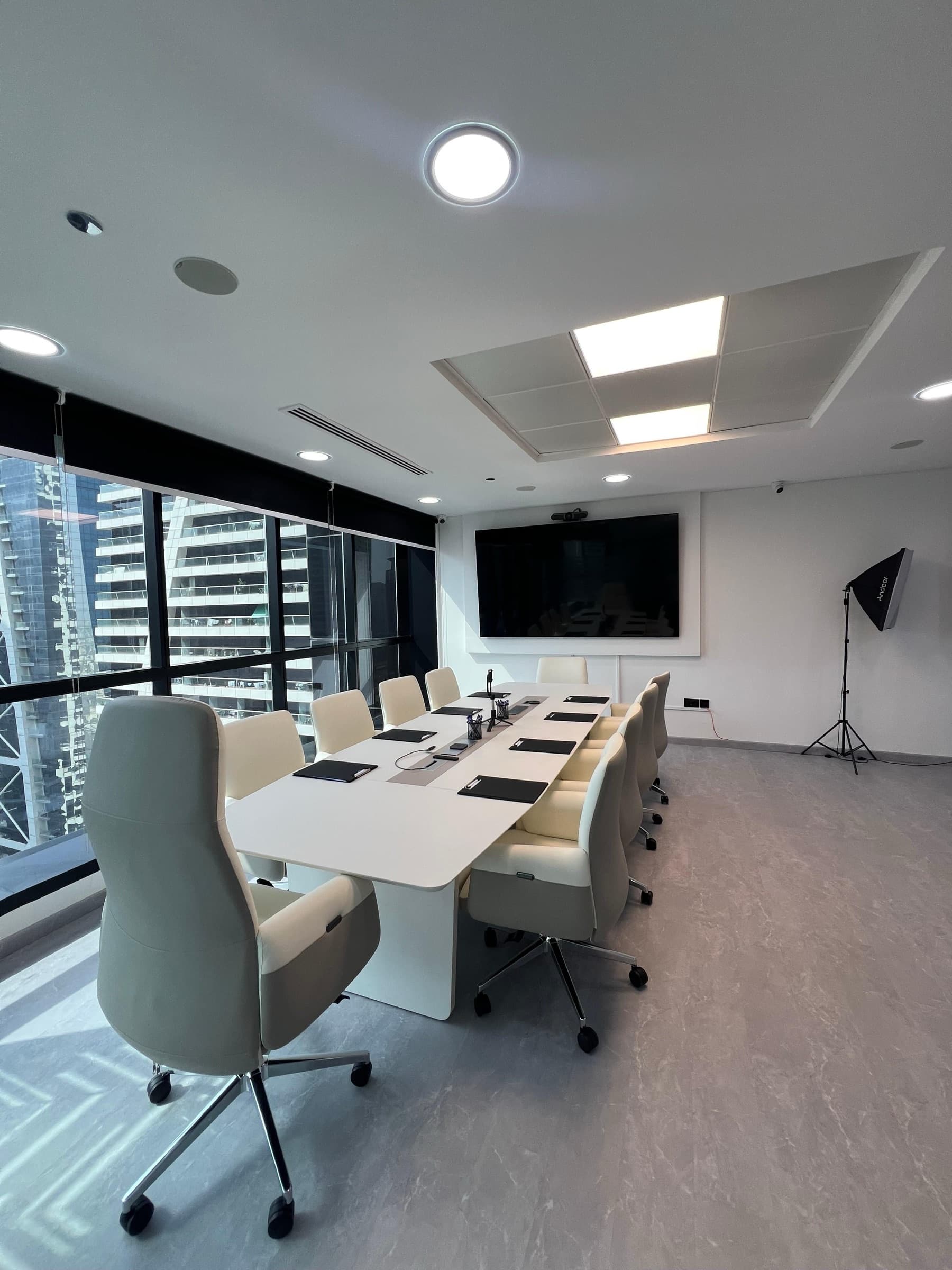 OpenReal boardroom with a long conference table and windows overlooking Dubai.