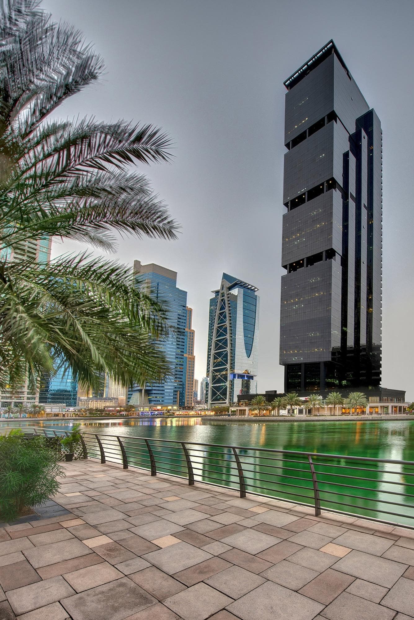 Dubai waterfront office district with modern towers and palm-lined walkways.